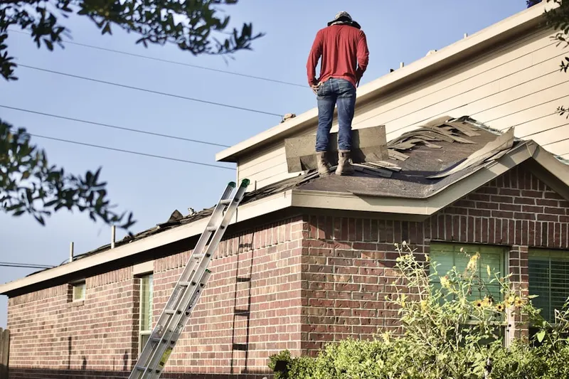 Professional roofer working on a residential roof in Long Branch